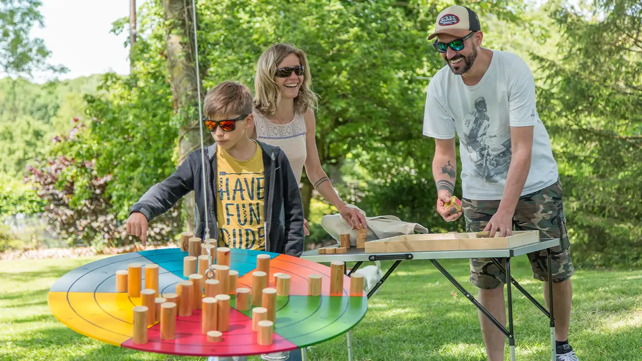 Famille jouant aux jeux géants en bois au parc Au Grand Air à Vonnas, près de Bourg-en-Bresse