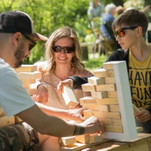 deux adultes et un enfant jouent dans le parc de jeux extérieur Au Grand Air (Vonnas, Ain, Rhône-Alpes)