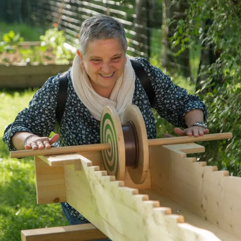 femme joue à la meule - jeu en bois disponible à la location Au Grand Air (Rhône-Alpes)