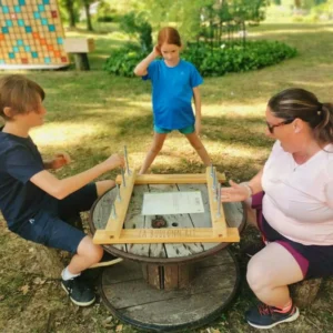 une famille joue au jeu de dextérité "Boulonn'rit" inventé par Au Grand Air (Vonnas)