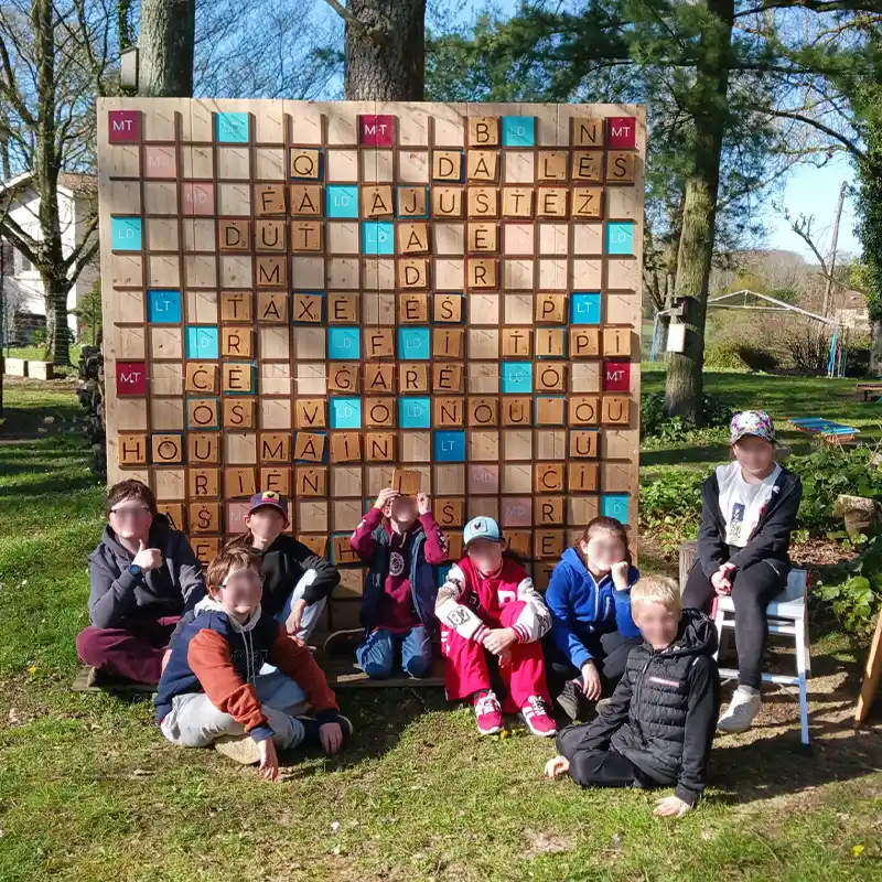 huit enfants de 10 ans réunis devant le scrabble d'Au Grand Air pendant une fête d'anniversaire dans l'Ain